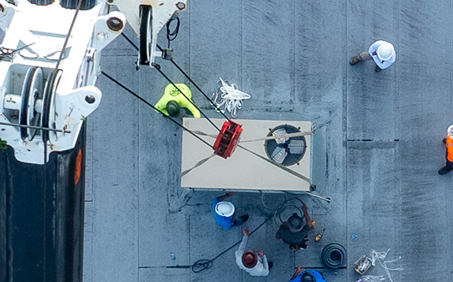 Rooftop construction with crane and HVAC installation