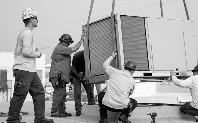 Construction workers installing HVAC unit